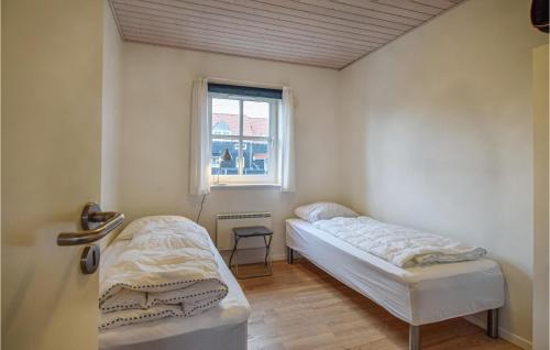 two beds in a room with a window at Holiday Home Strandengen Juelsminde Denm in Juelsminde