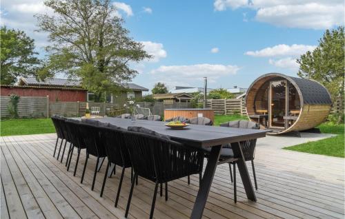 a patio with a table and chairs on a wooden deck at Nice Home In Ebeltoft With Sauna in Ebeltoft