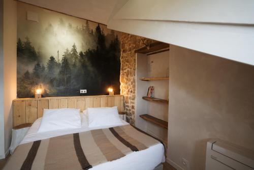 a bedroom with a bed with a painting on the wall at Bed & Breakfast Perbos 1556 in Labastide-Clairence