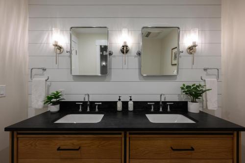 a bathroom with two sinks and two mirrors at Academy Place | Wild Iris in Crested Butte