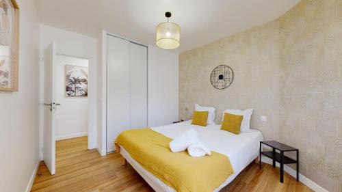 - une chambre avec un grand lit blanc et des draps jaunes dans l'établissement 865 Suite Jasmin - Superbe appartement, à Montreuil