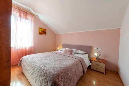 a bedroom with a large bed and a window at Villa Nick in Cavtat