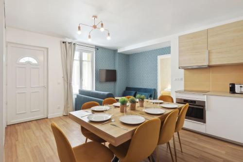 une cuisine et une salle à manger avec une table et des chaises dans l'établissement 864 Suite Iris - Superbe appartement, à Montreuil