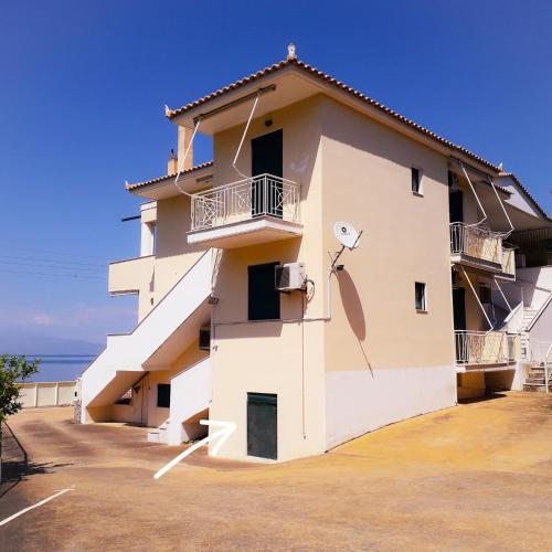 a building with a satellite on the side at Derveni Seaside Apartments - Deluxe Sea View Penthouse Jacuzzi-BBQ & Groundfloor Garden View Apartment in Derveni