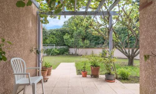 une terrasse avec une chaise blanche et des plantes en pot dans l'établissement villadujeudepaume, à Balma