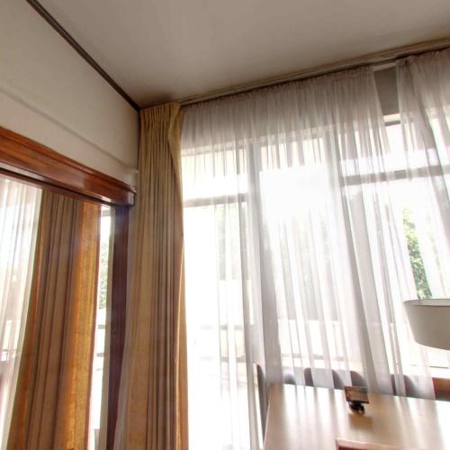 a room with a window with curtains and a table at GHION HOTEL in Addis Ababa