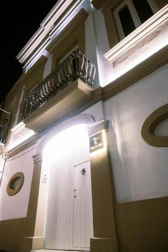 a white building with a door and a balcony at Relais Ena in Gallipoli