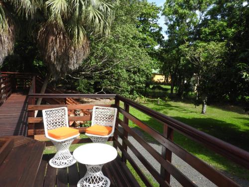 two chairs and a table on a wooden deck at Insolite Ara Wakan / Ma cabane in Pointe-Noire