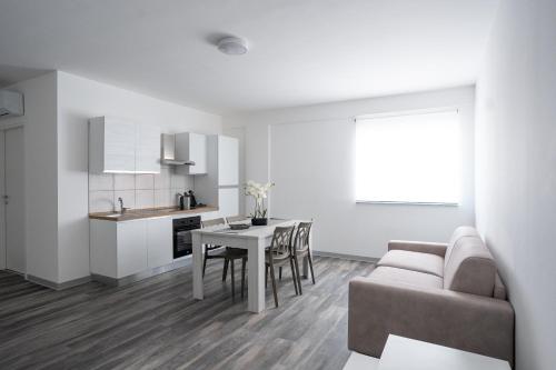 a kitchen and a living room with a table and a couch at Capri Residence in Casoria