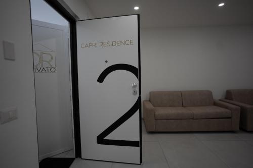 a room with a couch and a door with a sign at Capri Residence in Casoria