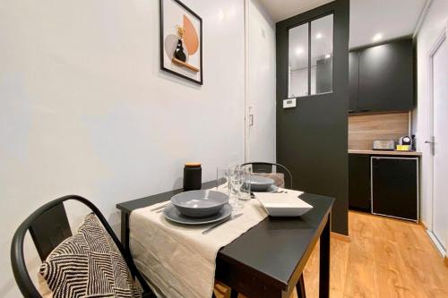 une salle à manger avec une table et des chaises noires dans l'établissement Pierre proche Place Saint Marc, à Rouen