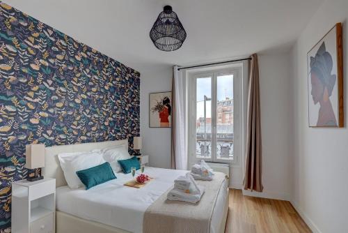 a bedroom with a white bed with a blue wall at 869-Suite Bleuet - Superbe Appartement in Montreuil