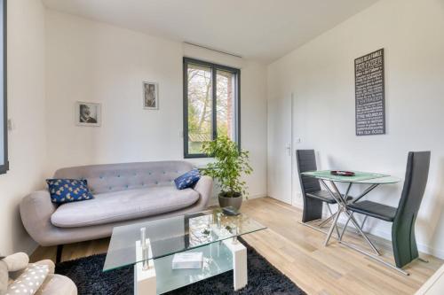 un salon avec un canapé et une table dans l'établissement Le Hameau Paisible Maison de Campagne, à Butot