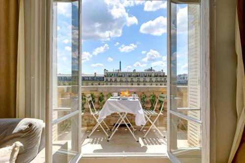 une chambre avec une table et une vue sur un bâtiment dans l'établissement Bluestay 245 -Duplex sur les Champs-Elysées+Balcon, à Paris