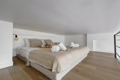 - une chambre avec 2 lits, des murs blancs et du parquet dans l'établissement Bluestay 245 -Duplex sur les Champs-Elysées+Balcon, à Paris