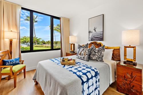 a bedroom with a bed and a chair and a window at Kaanapali Shores 104 in Kahana