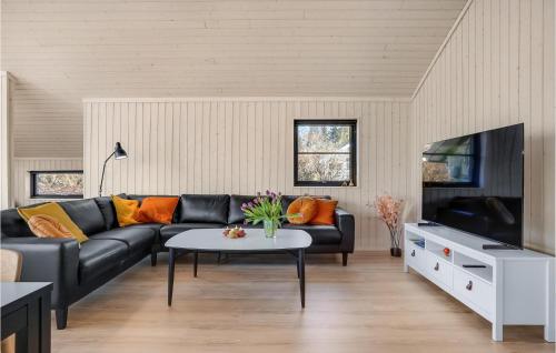 a living room with a black couch and a table at Cozy Home In Ebeltoft With Sauna in Ebeltoft