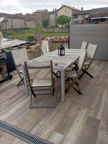 a wooden table and chairs on a patio at Petit moment de detente in Curzay-sur-Vonne