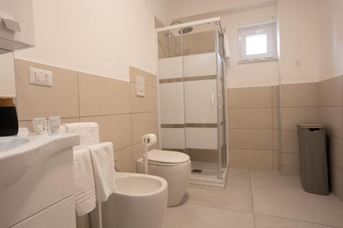 a white bathroom with a toilet and a shower at Capri Residence in Casoria