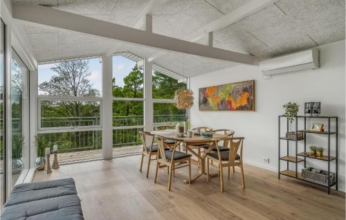 a dining room with a table and chairs and windows at Three-Bedroom Holiday Home In Spottrup in Lihme