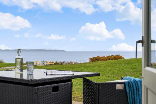a table and chairs with a view of the ocean at Cozy Brenderup Apartment on the beach in Brenderup