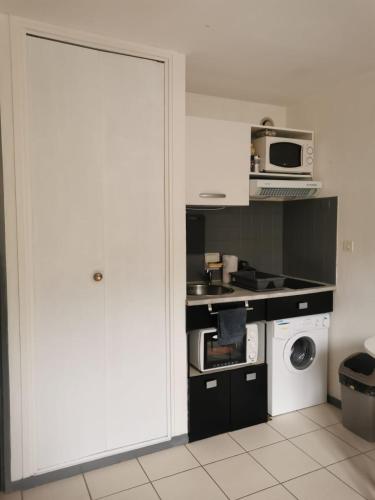 - une cuisine avec une porte blanche et un four micro-ondes dans l'établissement Studio au pied des pistes et des Cures, à Mont-Dore