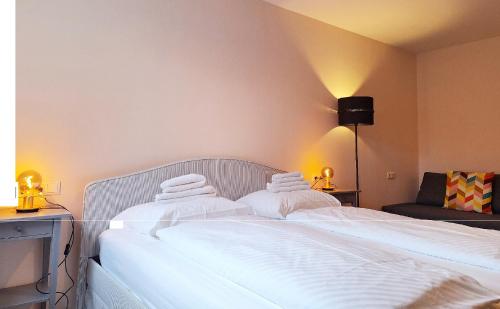 two beds in a hotel room with white towels at Dorf.Apart in Neustift im Stubaital