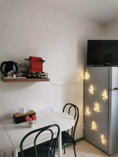 une cuisine avec une table et des chaises ainsi qu'une télévision dans l'établissement Studio au pied des pistes et des Cures, à Mont-Dore