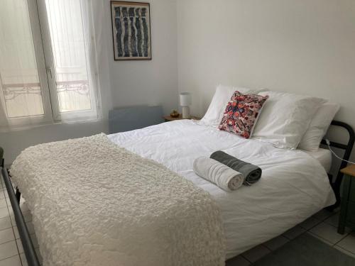 a bedroom with a white bed with towels on it at Au nom de la rose, beau 3 pièces en centre-ville in Provins