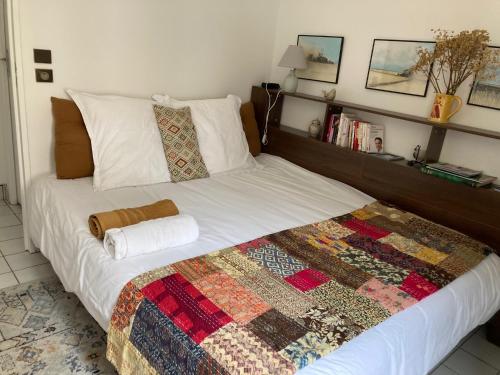 a bedroom with a bed with a quilt on it at Au nom de la rose, beau 3 pièces en centre-ville in Provins
