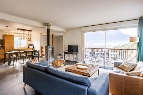 un salon avec un canapé bleu et une table dans l'établissement Les 5 Vallées - Appt en Duplex avec vue montagne, à Briançon