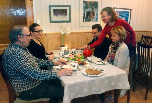 a group of people sitting around a table eating food at Hotelli Möhkön Rajakartano - Ilomantsi in Petkeljärvi