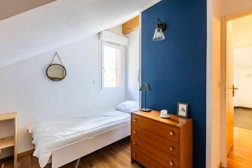 a bedroom with a bed and a blue wall at Les 5 Vallées - Appt en Duplex avec vue montagne in Briançon