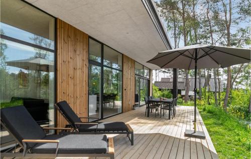 an outdoor patio with chairs and an umbrella at Lovely Home In Knebel With Kitchen in Knebel