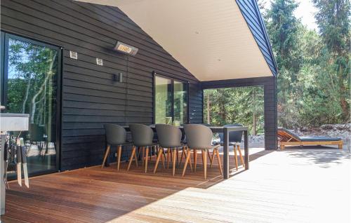 a black house with a table and chairs on a deck at Lovely Home In Nexø With Kitchen in Neksø