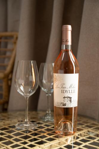 a bottle of wine and two wine glasses on a table at Celia Residence in Athens