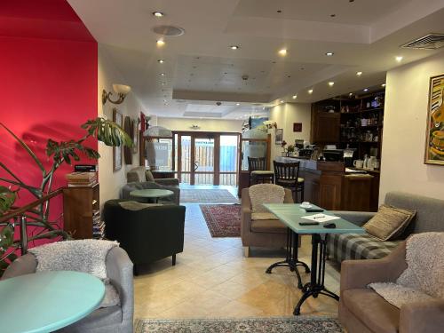 a living room with couches and tables and a kitchen at Kralev Dvor Hotel in Bansko