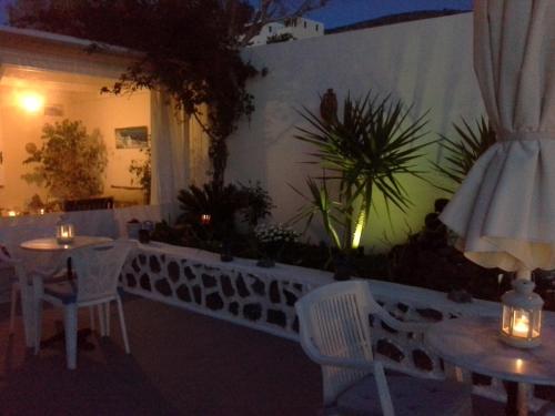 a patio with tables and chairs at night at Kiklamino Sunset Studios in Oia