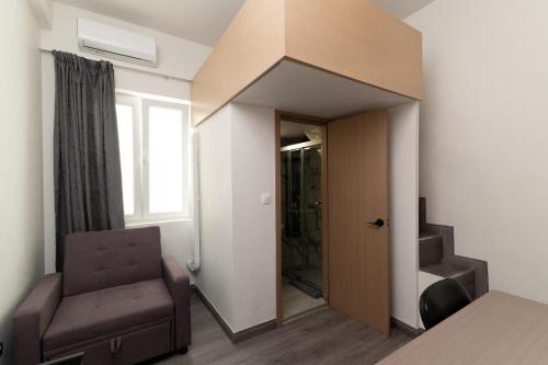a room with a chair and a door with a window at Celia Residence in Athens