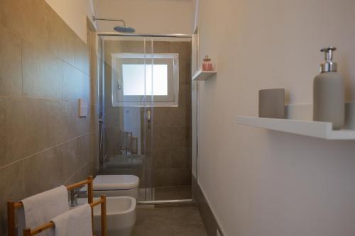 a bathroom with a shower and a toilet and a window at Appartamenti Luna - Stresa in Stresa