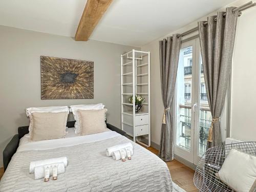une chambre avec un lit avec deux serviettes dessus dans l'établissement St Michel - Deluxe Apartment - Harpe, à Paris