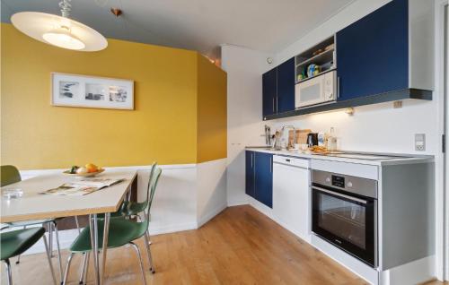 a kitchen with blue and yellow walls and a table at Fanø Bad, Lejl 111 in Fanø