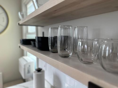 a row of wine glasses sitting on a shelf at Newly Renovated 1 Bedroom Executive Apartment in Kearny