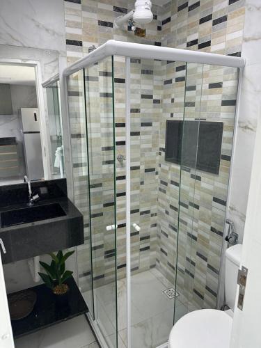 a bathroom with a shower and a sink and a toilet at Flat no Condominio Home Duplex Bezerros in Bezerros