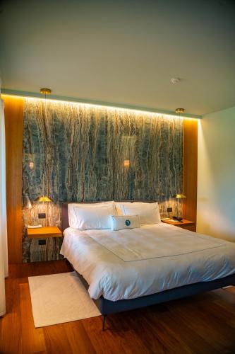 a bedroom with a large bed with a large window at Gallia Palace Hotel - Relais & Châteaux in Punta Ala