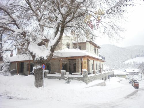 a house covered in snow in front of a tree at Lithos in Áyios Nikólaos
