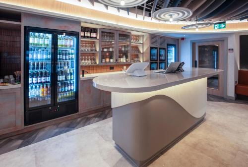 a bar in a restaurant with two laptops on a counter at ibis Styles Burton On Trent in Burton upon Trent