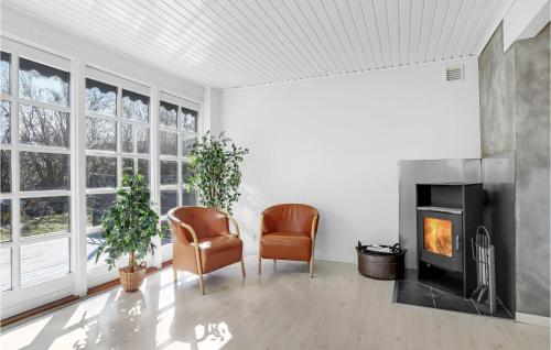 a living room with two chairs and a fireplace at 5 Bedroom Lovely Home In Allinge in Allinge