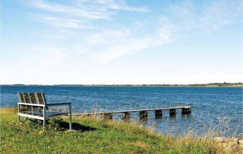 a bench sitting on the edge of a dock at 3 Bedroom Amazing Home In Stubbekøbing in Stubbekøbing