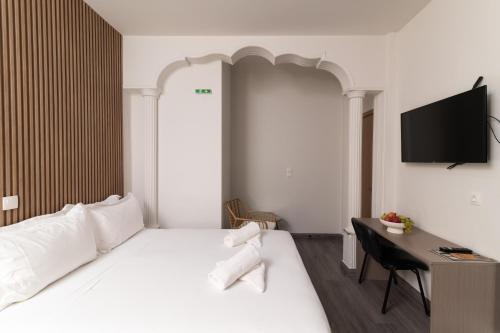 a bedroom with a bed and a desk with a television at Celia Residence in Athens